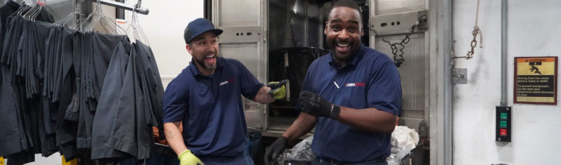 Lechner Services Route Service Representatives laughing while unloading garments