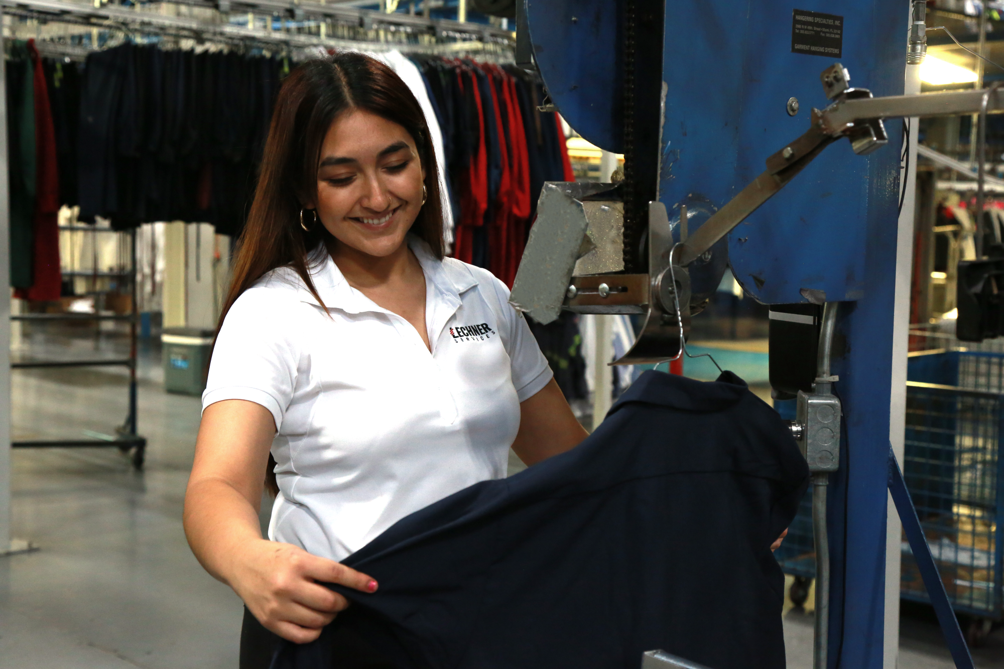 Lechner employee inspecting a uniform shirt for damages