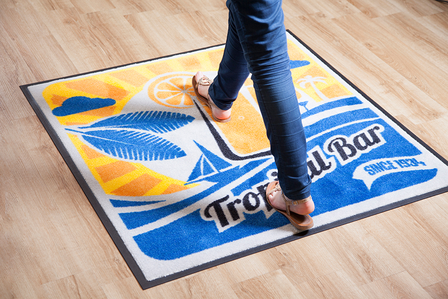 Person walking over a custom logo mat