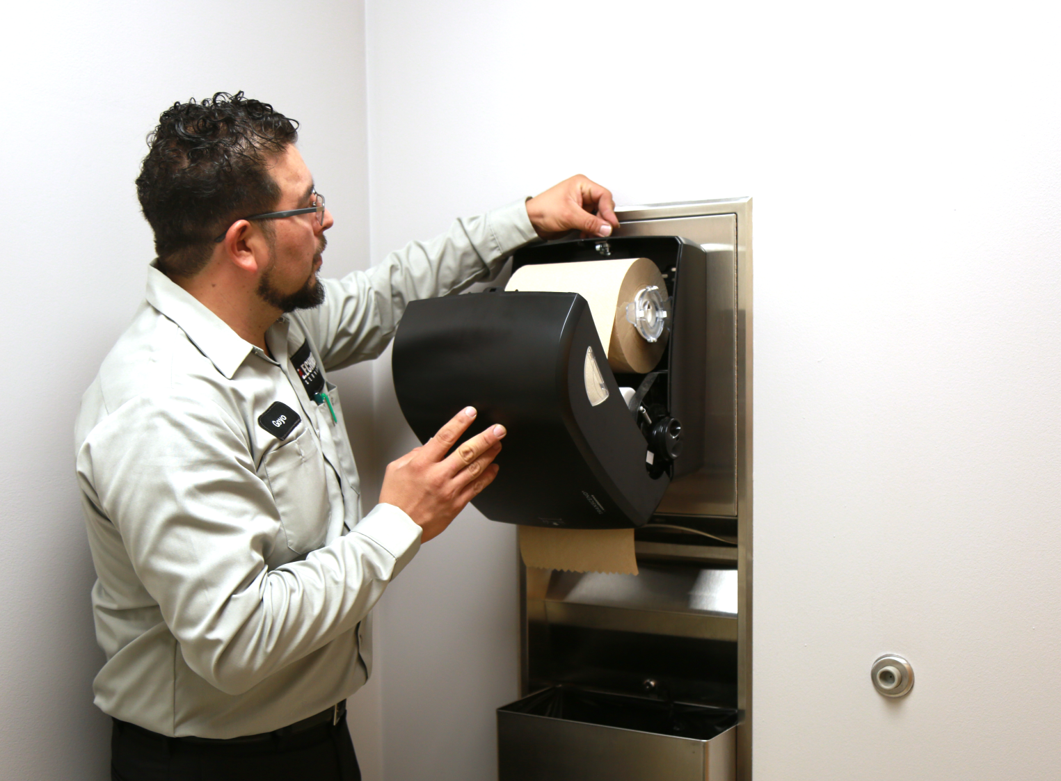 A Lechner Route Service Representative servicing a Transcend restroom towel dispenser