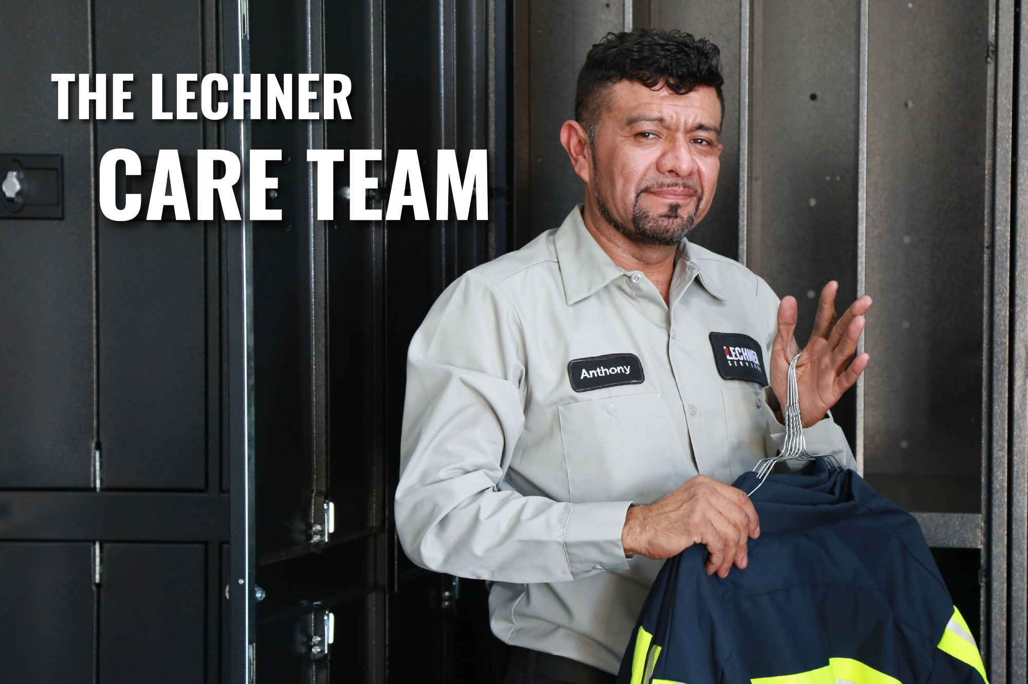 A Lechner Route Service Representative holding an enhanced visibility uniform in front of lockers